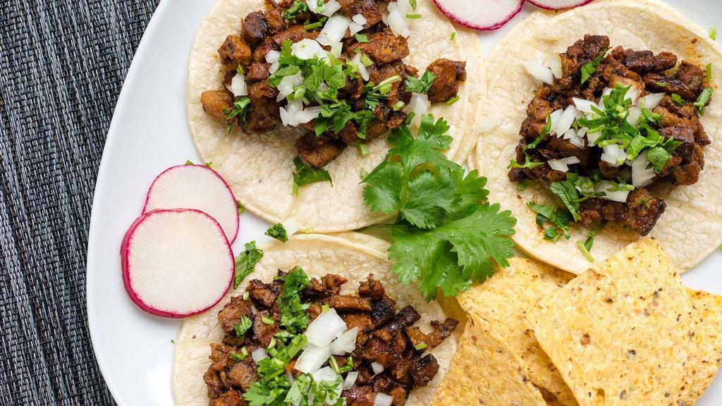 Street Tacos · Three soft corn tortillas topped with beef, chicken or pork al pastor, cilantro, onions, radish, and lime.