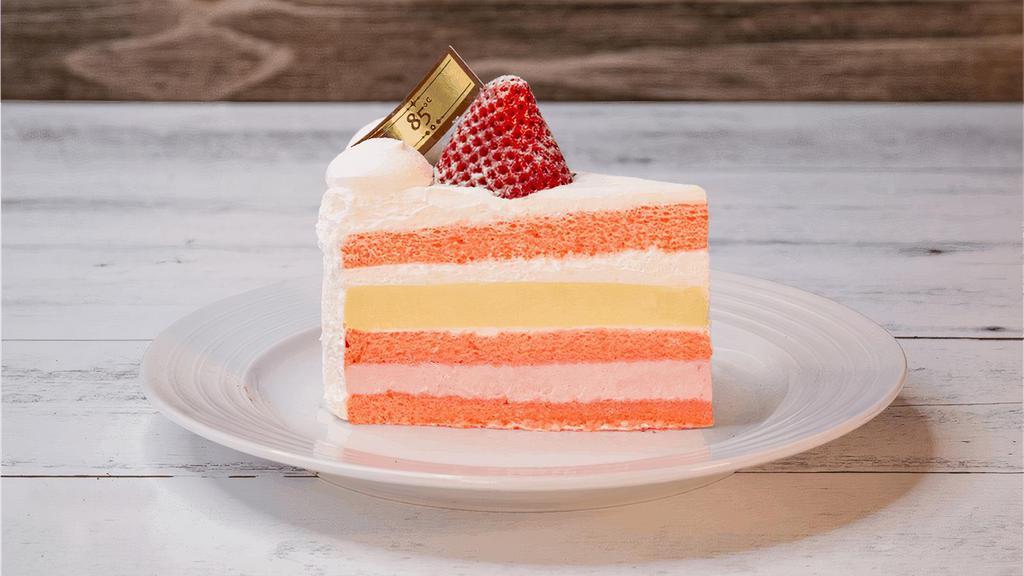 Deluxe Strawberry Cream | Slice · Strawberry chiffon cake layered with strawberry mousse and vanilla creme brulee. It is decorated with fresh cream, strawberry, and strawberry chocolate shaving.