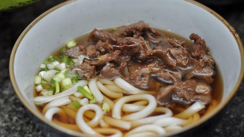 Niku (Beef) Udon Soup · Japanese-style soup, prepared with Udon (thick flour noodles), Beef, green onions, seaweed, sesame seed, and mixed vegetables.