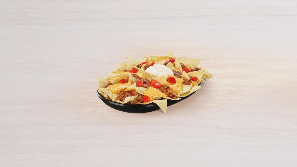 Nachos Bellgrande® · A portion of crispy tortilla chips topped with warm nacho cheese sauce, refried beans, seasoned beef, ripe tomatoes and cool sour cream.