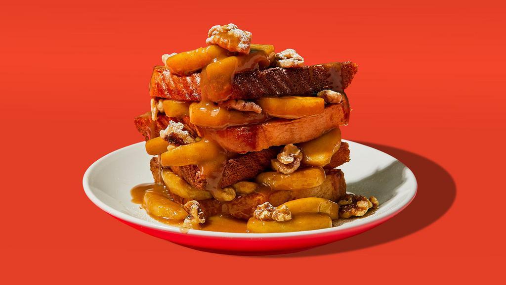 Apple Stuffed Cinnamon French Toast · Two slices of egg-washed french toast stuffed with caramel glazed apples and walnuts and topped with maple syrup and butter.
