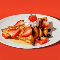 Mixed Berry French Toast · Two slices of egg-washed french toast topped with strawberries, blueberries, whipped cream, ...