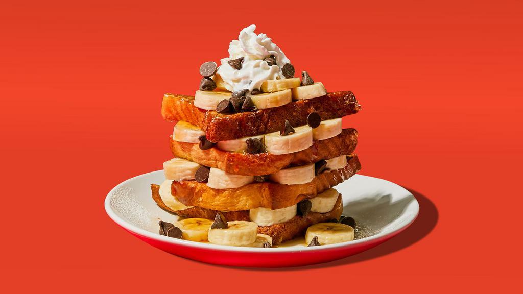 Chocolate Chip Banana French Toast · Two slices of egg-washed french toast topped with banana, chcocolate chips, whipped cream, maple syrup and butter.