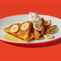 Banana French Toast · Two slices of egg-washed french toasttopped with banana, whipped cream, maple syrup and butt...