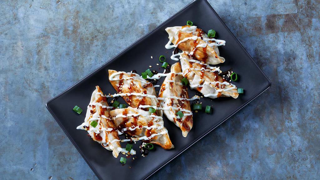 Korean Wasabi Pot Stickers · Steamed pork dumplings drizzled with Korean BBQ sauce and Cucumber-Wasabi Ranch. Topped with green onions and sesame seeds.