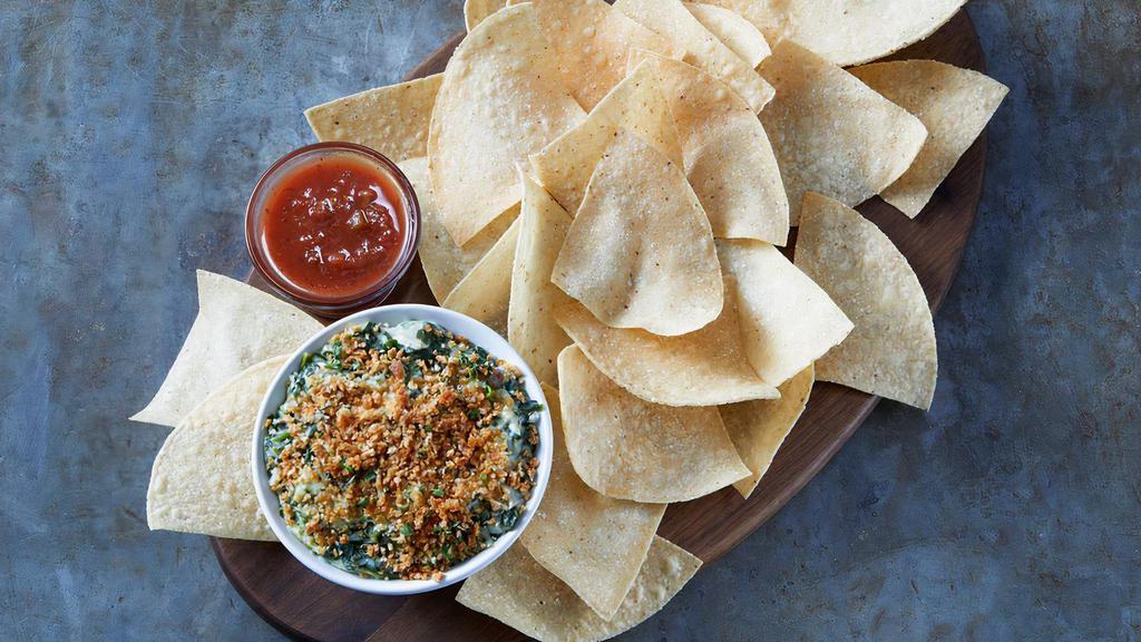 Classic Spinach Dip · The classic shareable dip- Spinach, artichokes, Romano, sauteed onions, red bell peppers, Parmesan breadcrumbs served with tortilla chips and salsa.