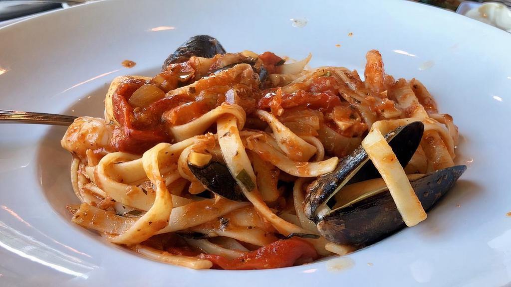 Spicy Frutti di Mare · Fresh Atlantic salmon, mussels & jumbo shrimp in a spicy tarragon cream sauce with roasted red peppers tossed with fettuccine pasta.