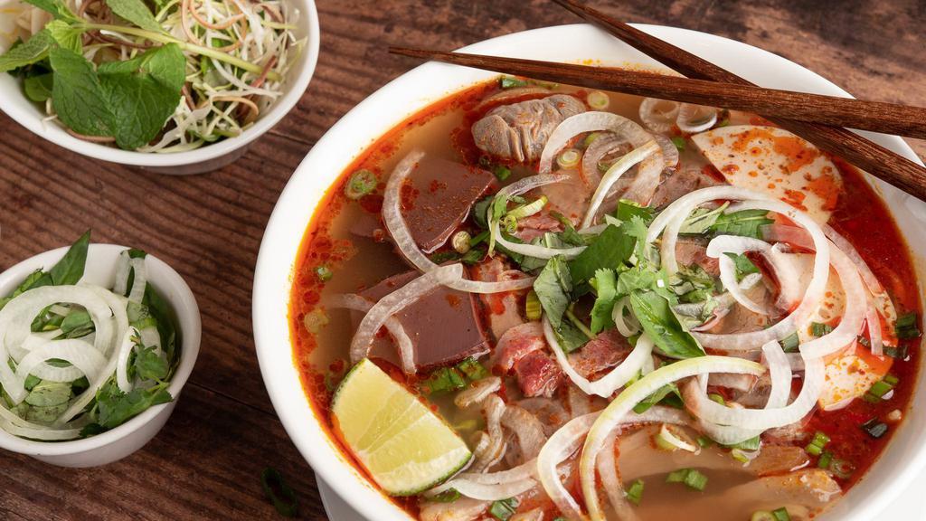 7. Bún Bò Huế  Đặc Biêt New Ca Mau · Popular and famous special Spicy noodle soup w/pork leg, Pork blood, Shanks, Brisket ,tendon, rare Beef, VN Ham