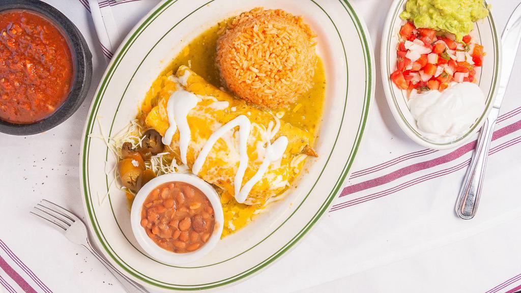 Enchiladas Suizas · Enchiladas filled with chicken tinga, Mexican cheese mix, onions, and cilantro, topped with salsa verde and crema, served with Mexican rice and frijoles charros.