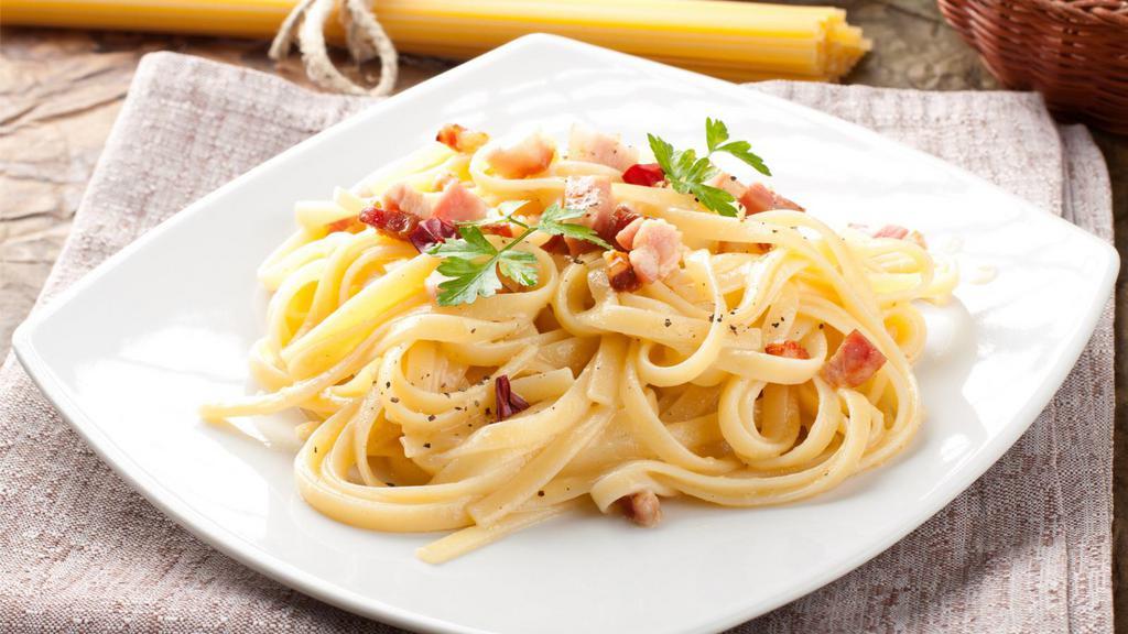 Fettuccine Carbonara · Fettuccine tossed with a rich, pink sauce, onions, tomatoes, garlic, Canadian and American bacon.