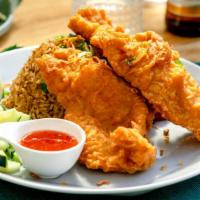 Fried chicken Over fried rice · Breaded fried chicken breast over fried rice, egg and onions served with sweet and sour sauce