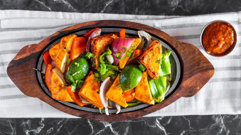 Tandoori Paneer Tikka · Marinated Indian Cottage cheese cubes, layered with Bell pepper and onions, roasted in charcoal-fired Clay-oven.