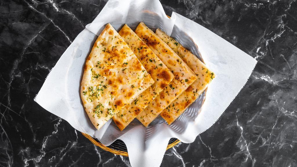 Garlic Naan · White Flour Bread laced with garlic and cilantro Baked In Charcoal Fired Clay Oven