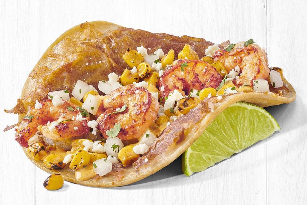 Mexican Street Corn Shrimp Taco (A La Carte) · Grilled shrimp, a toasted blend of cheeses, fire roasted corn, cotija cheese, creamy chipotle white sauce, and cilantro & onion. Served on a stone-ground corn tortilla.