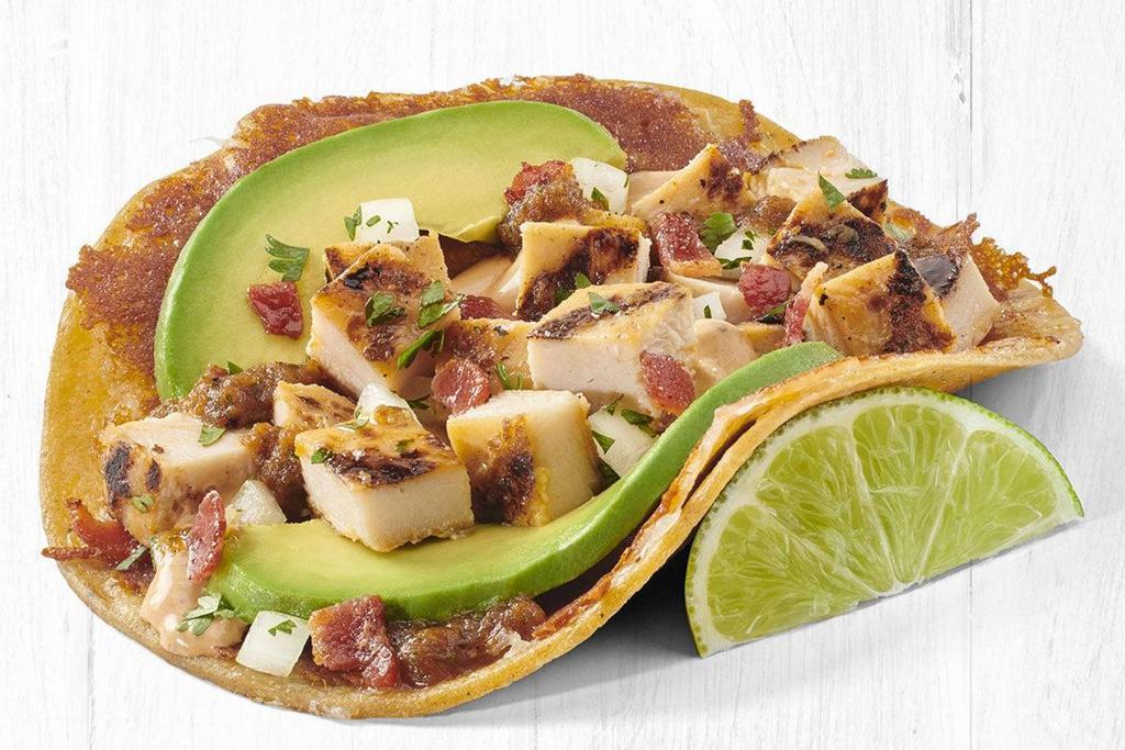 Grilled Gourmet™ Chicken Taco (A La Carte) · Grilled All Natural Chicken served on a corn tortilla with toasted cheese, bacon, Hass avocado slices, roasted chipotle salsa, creamy chipotle sauce and cilantro/onion mix.