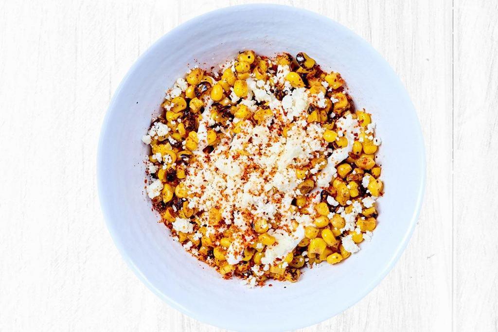 Mexican Street Corn - Large Side · Fire roasted corn topped with cotija cheese, white sauce and tajin.
