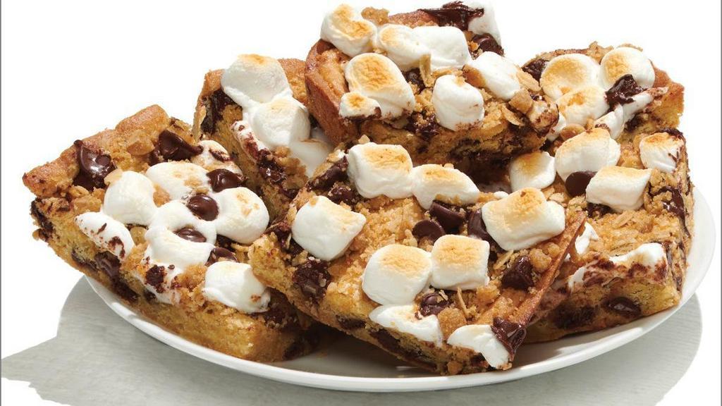 S'Mores Bars - Baking Required · Scratch-made Cookie Dough with Chocolate Chips spread into a tray and topped with Marshmallows, Chocolate Chips, and Crisp Topping