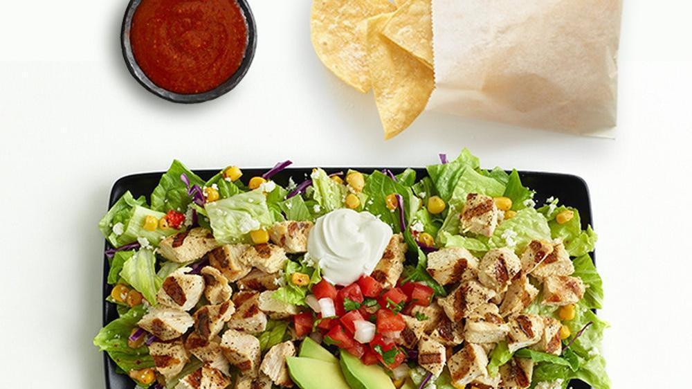 Double Chicken Avocado Salad · Savor organic super greens and lettuce topped with a double portion of our fire-grilled chopped chicken,  avocado, cotija crumbles, corn, and pico. Includes choice of dressing. Keto-Friendly. 7g net carbs. Dressing not included in calories or net carbs. Includes chips and salsa.