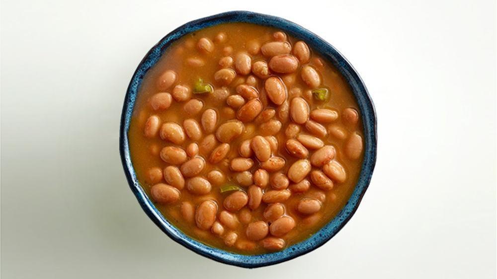 Pinto Beans · Whole pinto beans simmered in their own juices with bits of serrano peppers.