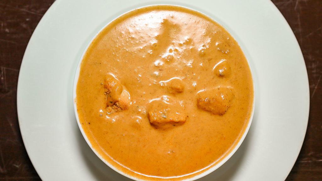 Chicken Tikka Masala · Tandoori baked chicken breast cooked in a smooth nutty curry with a touch of saffron with onions, ginger, garlic, vine ripened and spices.