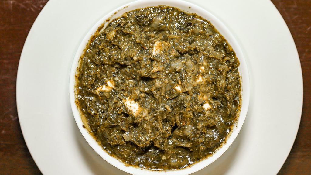 Saag Paneer · Homemade cottage cheese cubes cooked with fresh spinach leaves with a little yogurt, ginger, garlic, and tomatoes.