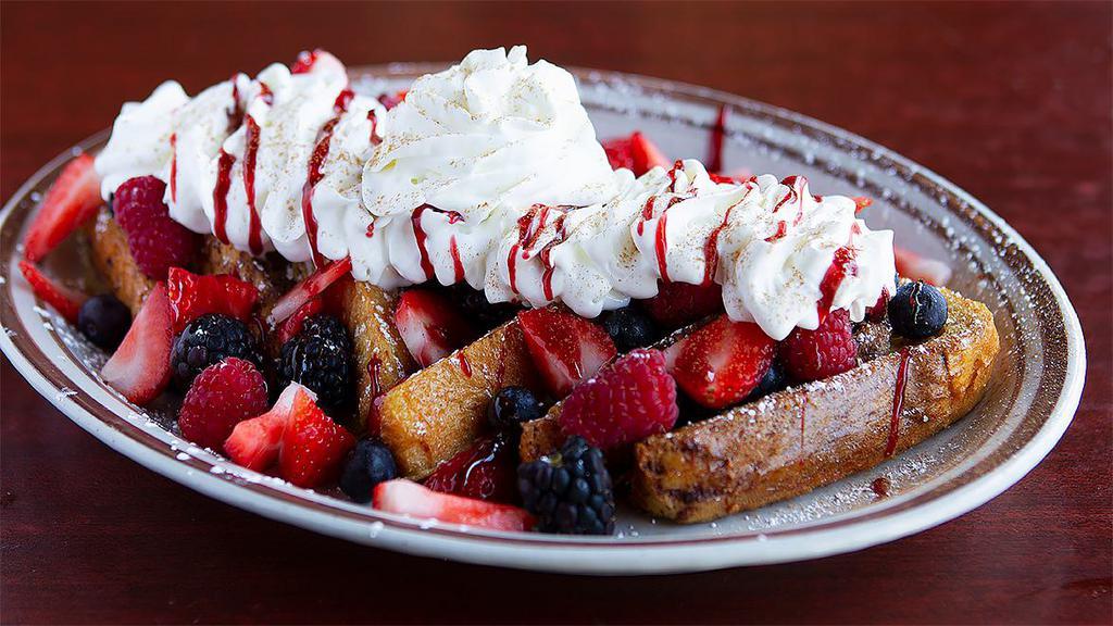 Berry Berry French Toast · Topped with blackberries, strawberries and blueberries and topped with whipped cream and raspberry sauce. Dipped in vanilla cinnamon egg batter.