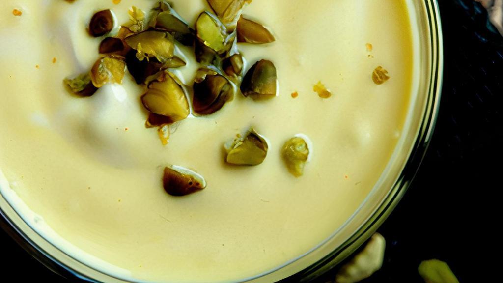 Saffron Pistachio Lassi · Chefs special blend on a traditional yogurt based drink with  earthiness of the saffron, complex flavor of crushed cardamom and bits of pistachio.