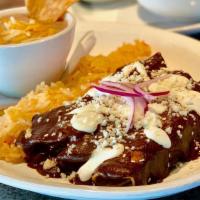 Chicken Mole · Chicken breast smothered in our house-made Mole, served with rice and charro beans.