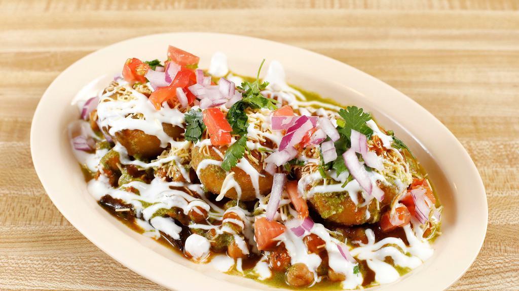 Tikki Chat (Aloo Chup) · Fried potato patty serve with chana masala, dreasale with yogurt, mint and tamarin.