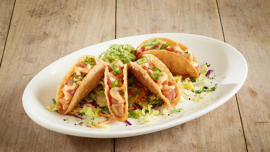 Ahi Poke Tacos* · Crispy wonton taco shells | sashimi-grade ahi tuna | green onions | poke sauce | creamy sriracha aioli | wasabi guacamole for dipping