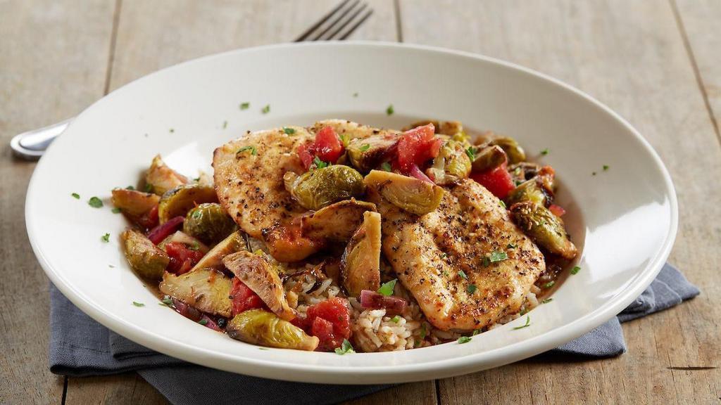 Enlightened Lemon Thyme Chicken · Herb-roasted chicken breasts | Big Poppa Smokers’ Desert Gold rub | brown rice | sautéed red onions | fire-roasted red peppers | tomatoes | roasted brussels sprouts | lemon thyme sauce