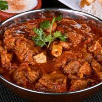 Traditional Goat Curry · Goat meat sautéed in onion tomato curry and flavored with aromatic spices.
