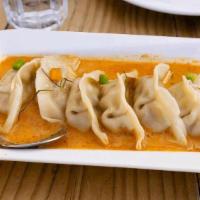 Dumplings with red curry / เกี๊ยวซ่าแกงแดง · Steamed Dumplings Chicken and vegetable with red curry sauce, topped. with diced bell pepper...