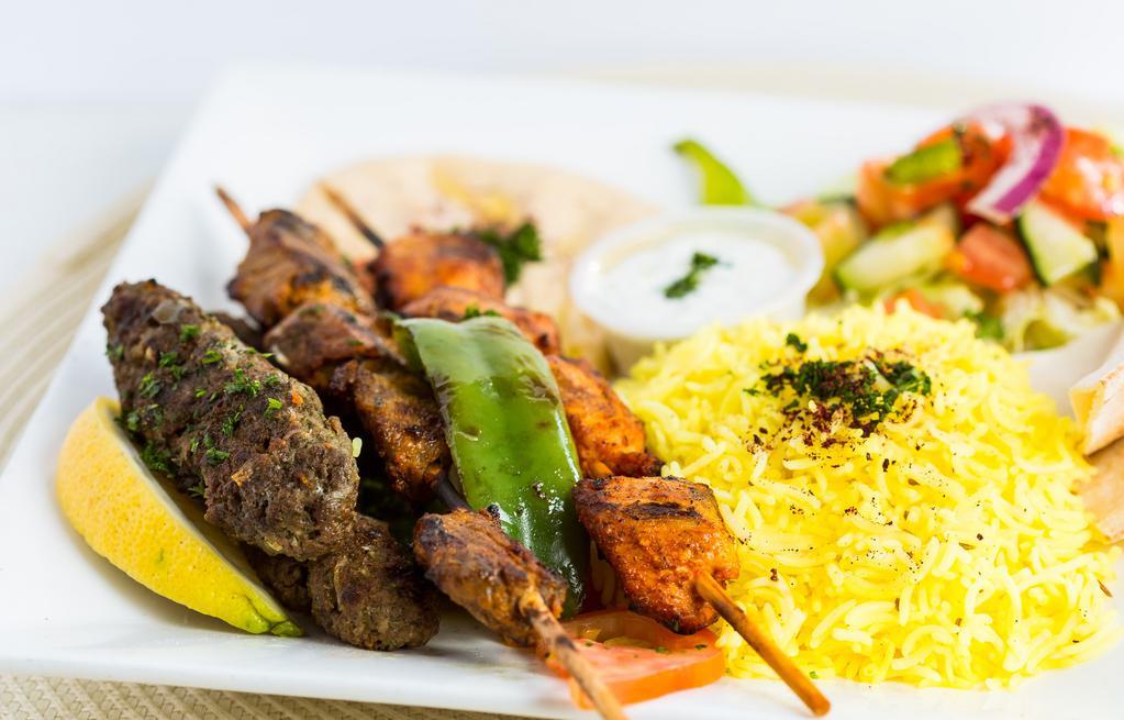 Two Meat Combo Kabob · Choice of any two kabobs topped with grilled onions & tomatoes over basmati saffron rice with whole cumin seeds, served with hummus, Mediterranean salad and homemade pita bread.