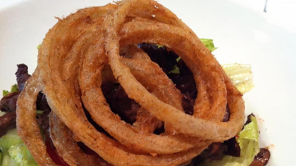 Spicy Beef Salad · Thin slices of steak sautéed in our spicy sauce, served on a bed of tomato, cucumber, and hearts of romaine, tossed in a light vinaigrette dressing. Garnished with onion rings and fresh herbs.