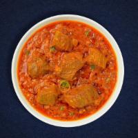 The Goat Curry Conspiracy · Goat cooked in a tomato based onion gravy with freshly ground spices.