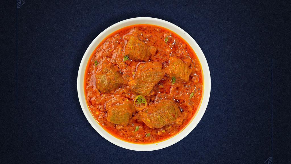 The Goat Curry Conspiracy · Goat cooked in a tomato based onion gravy with freshly ground spices.