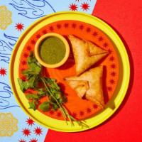 Chicken Samosas · Two samosas filled with chicken and wrapped in a light pastry.