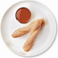 Churro With Dulce De Leche Dipping Sauce · One churro cut in half and served with a side of dulce de leche dipping sauce