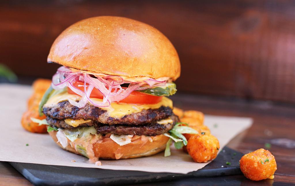 All American Burger* · two grilled quarter-pound beef patties, american cheese, shredded lettuce, tomato, red onion, pickles, bark + bite sauce [980 cal] .