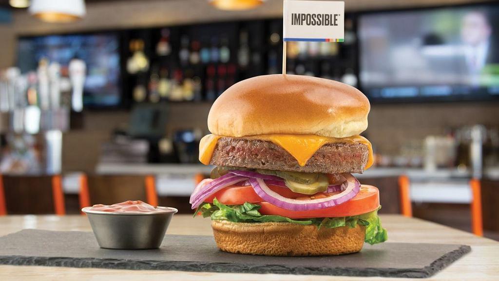 New School Impossible™ Cheeseburger · Impossible™ Burger • tillamook cheddar • lettuce blend • tomatoes • red onions • pickles • the counter relish • brioche bun