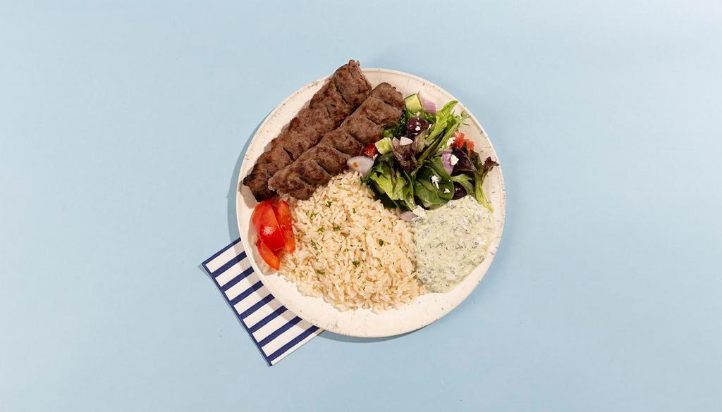 Ground Beef Kabob Rice Platter · Grilled ground beef kabob served with rice, salad, pita bread, and tzatziki.