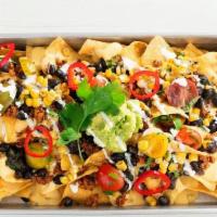 Southwestern Nachos  · Serves 2 | Corn chips, queso sauce, Tex-Mex style taco meat, ranchero beans, roasted tomato ...