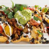 Southwestern Nachos  · Serves 2 | Corn chips, queso sauce, Tex-Mex style taco meat, ranchero beans, roasted tomato ...