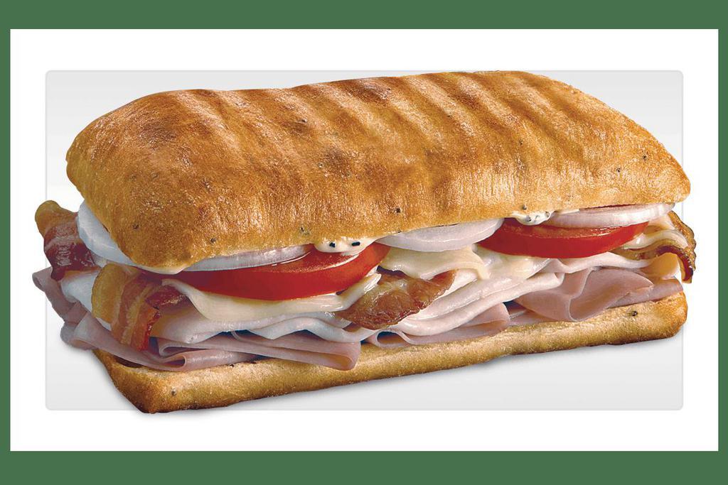 Ultimate Club · Slow-cured ham, oven-roasted turkey, crisp bacon, Swiss, tomatoes, and onion with peppercorn ranch dressing