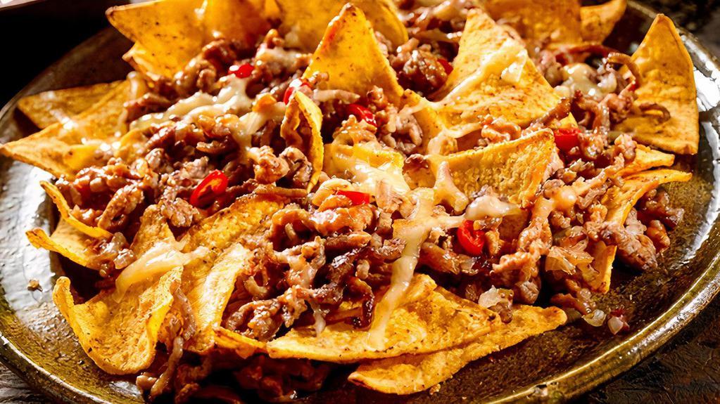 Grilled Steak Nachos · Delicious Nacho chips topped with Grilled Steak, beans, cheese, and salsa.