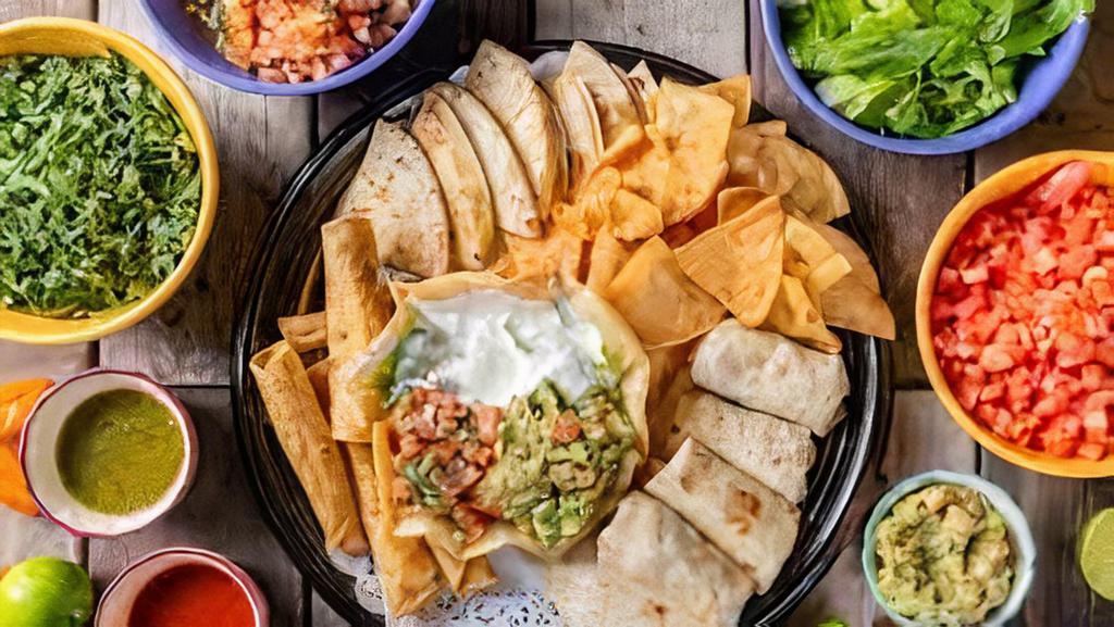 Fiesta Platter · Delicious platter made with Nachos, garlic prawns, chicken flauta, corn quesadilla, grilled onions, guacamole, sour cream, and salsa.
