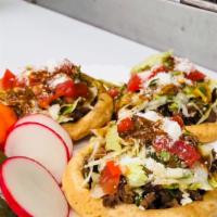 Sopes (3) · Three sopes hand made from corn flour filled with your choice of meat and topped with refrye...