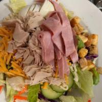 Chef's Salad · A tossed green salad is topped with a slices of turkey, ham, cheddar and jack cheeses, slice...