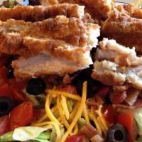 Crispy Chicken Salad · A tossed green salad is topped with a pieces of crunchy fried chicken, sliced tomato, sliced...